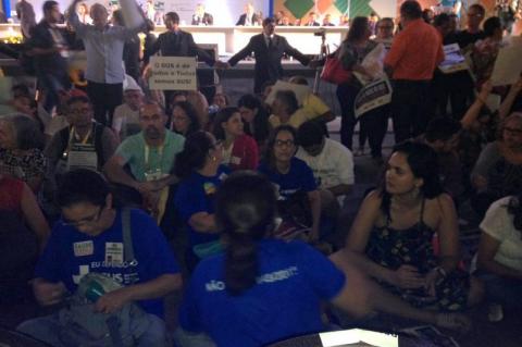 De costas para o ministro da Saúde: cartazes dizem “não ponham a mão no SUS”; a cada palavra de Ricardo Barros, uma onda de vaias e manifestações de repúdio (Foto: Adelante – Coletivo Saúde e Democracia)